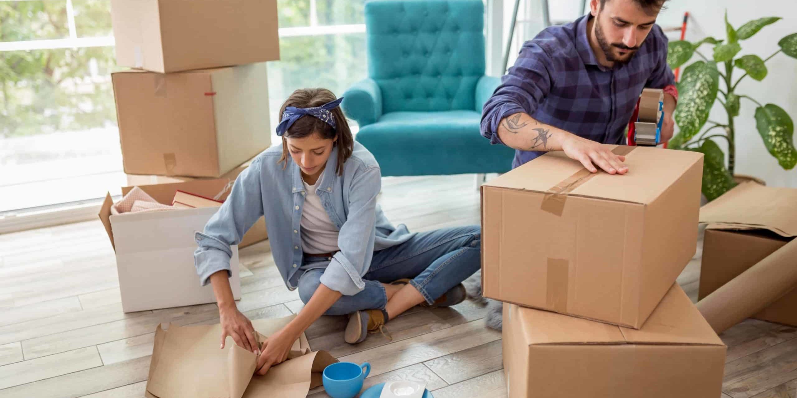 Couple dans leur salon avec des cartons